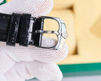 Omega wristwatch side view with metal buckle and black leather strap on cuff.