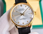Gold-tone wristwatch with black leather strap, white dial, Roman numerals and date window