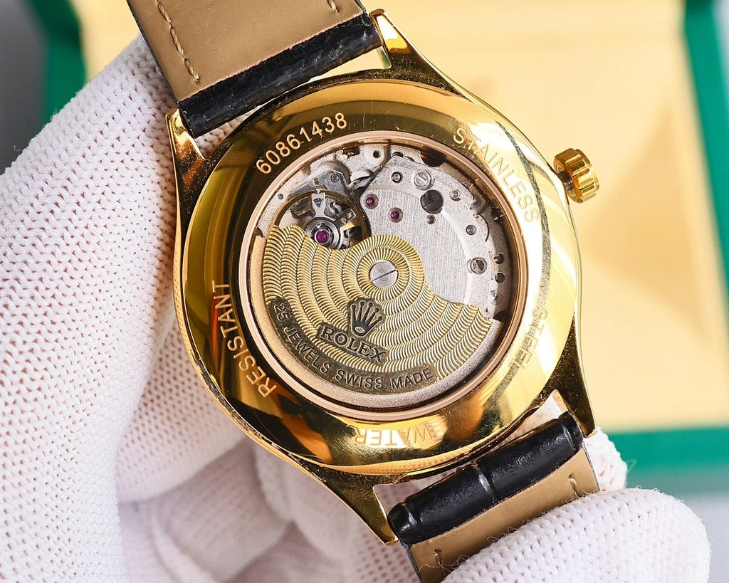 Gold-tone watch case back with visible mechanical movement and black leather strap