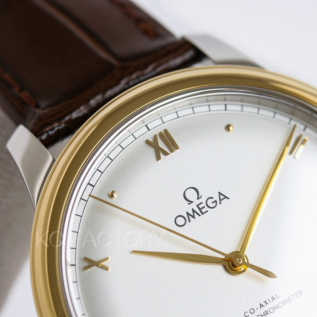 Omega watch closeup: champagne dial with Roman numerals, gold hands, brown leather strap.