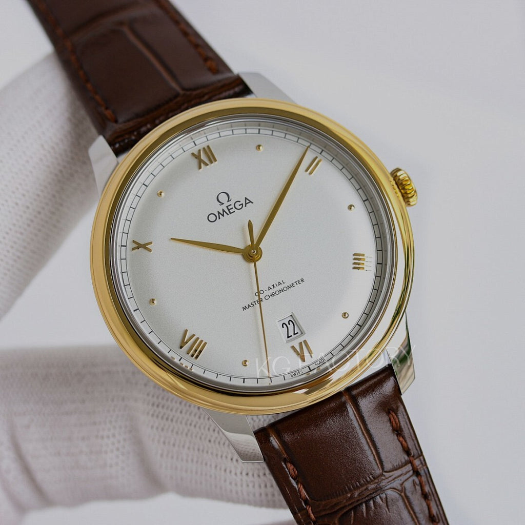 Omega watch with gold tone case, white dial, brown leather strap, roman numerals and date.