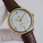 Omega watch with gold tone case, white dial, brown leather strap, roman numerals and date.
