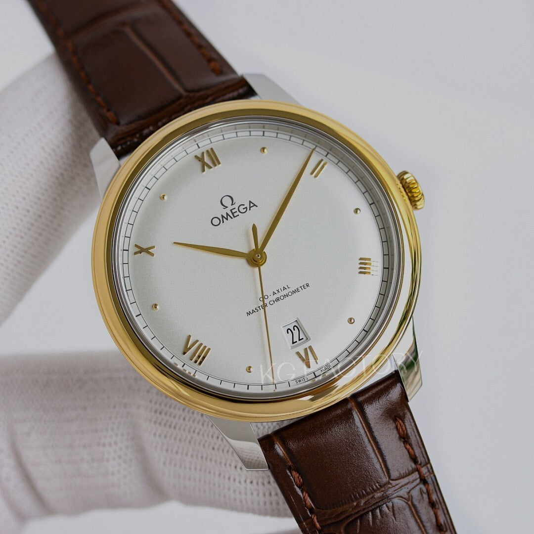 Omega watch with gold tone case, white dial, brown leather strap, roman numerals and date.