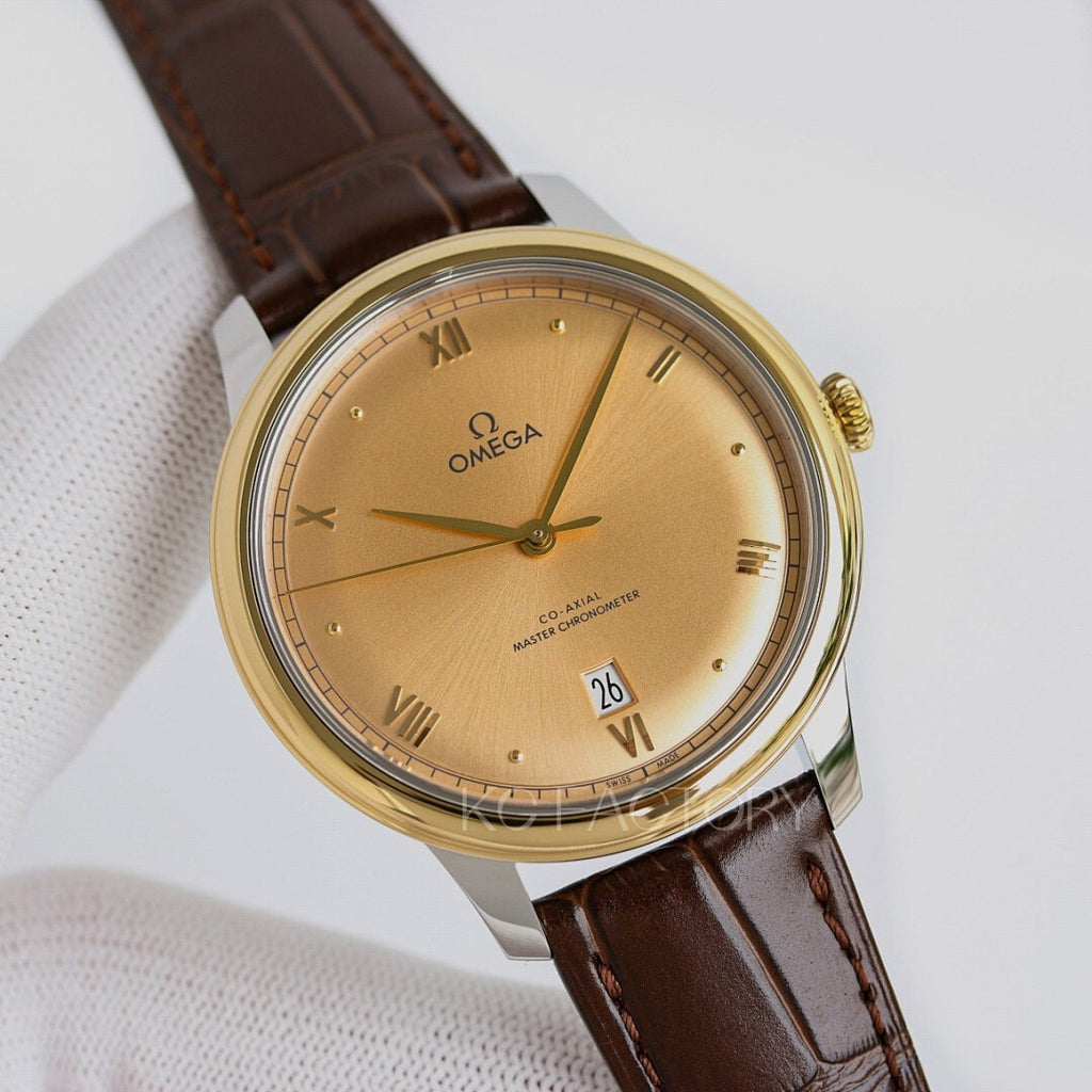 Omega watch with gold tone case, beige dial, brown leather strap, roman numerals.