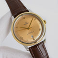 Omega watch with gold tone case, beige dial, brown leather strap, roman numerals.