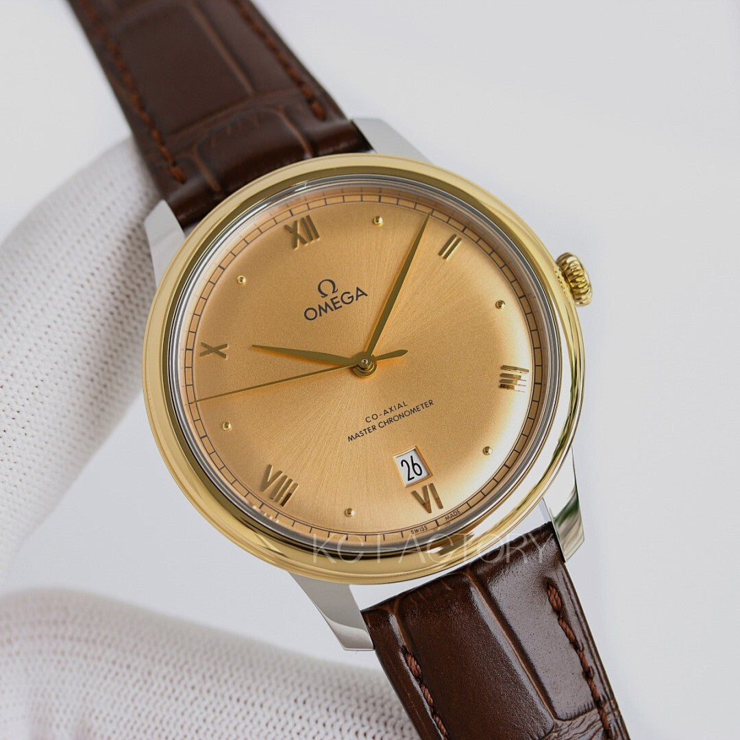 Omega watch with gold tone case, beige dial, brown leather strap, roman numerals.