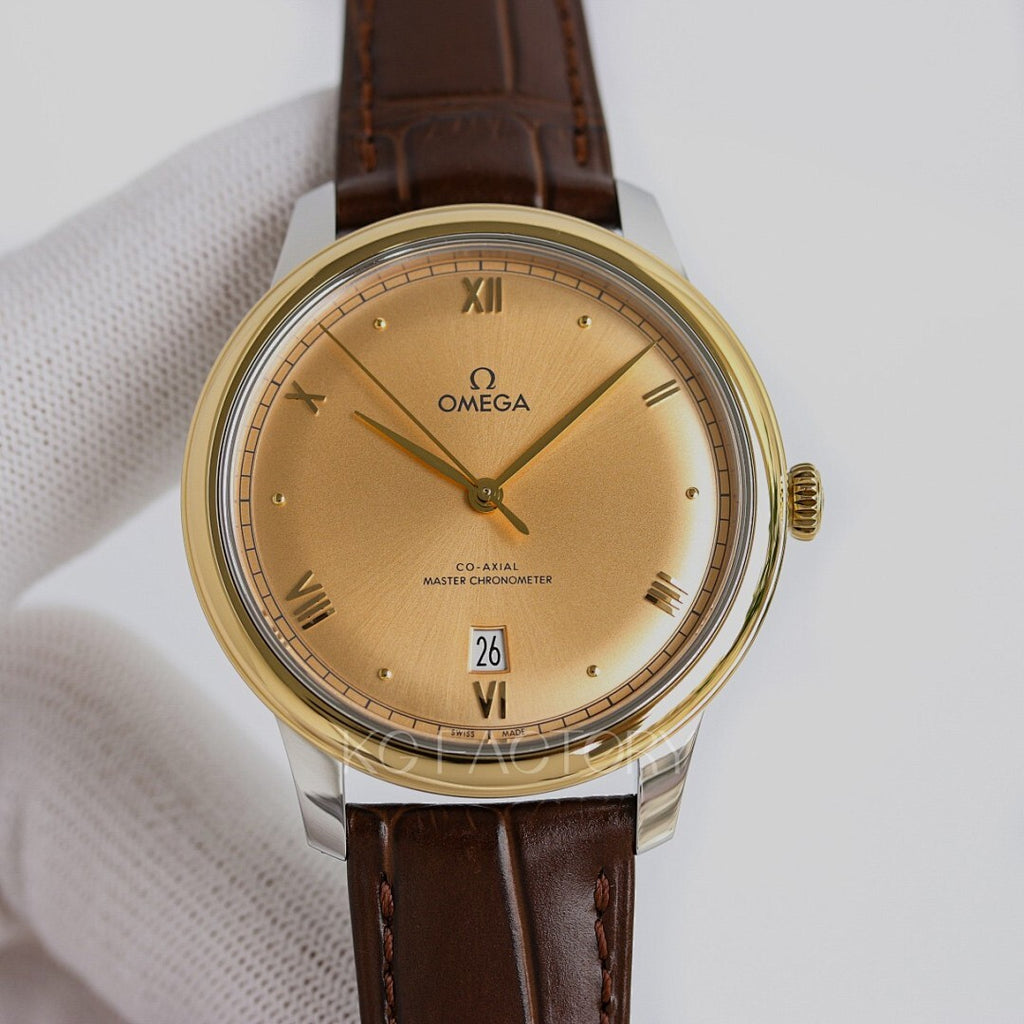 Omega watch with gold tone case, champagne dial, brown leather strap, Roman numerals, date 26.