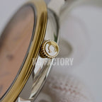 Gold-tone watch crown and case side on a metal wristwatch