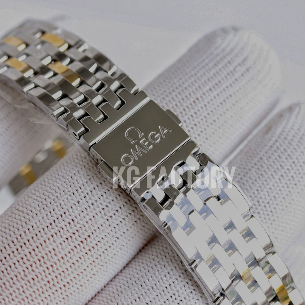 Two-tone metal watch bracelet with clasp detail on a white cuff