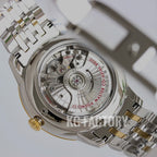 Two-tone wristwatch caseback with visible movement and gold accents