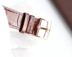 Omega watch brown leather strap with gold-tone buckle and keeper