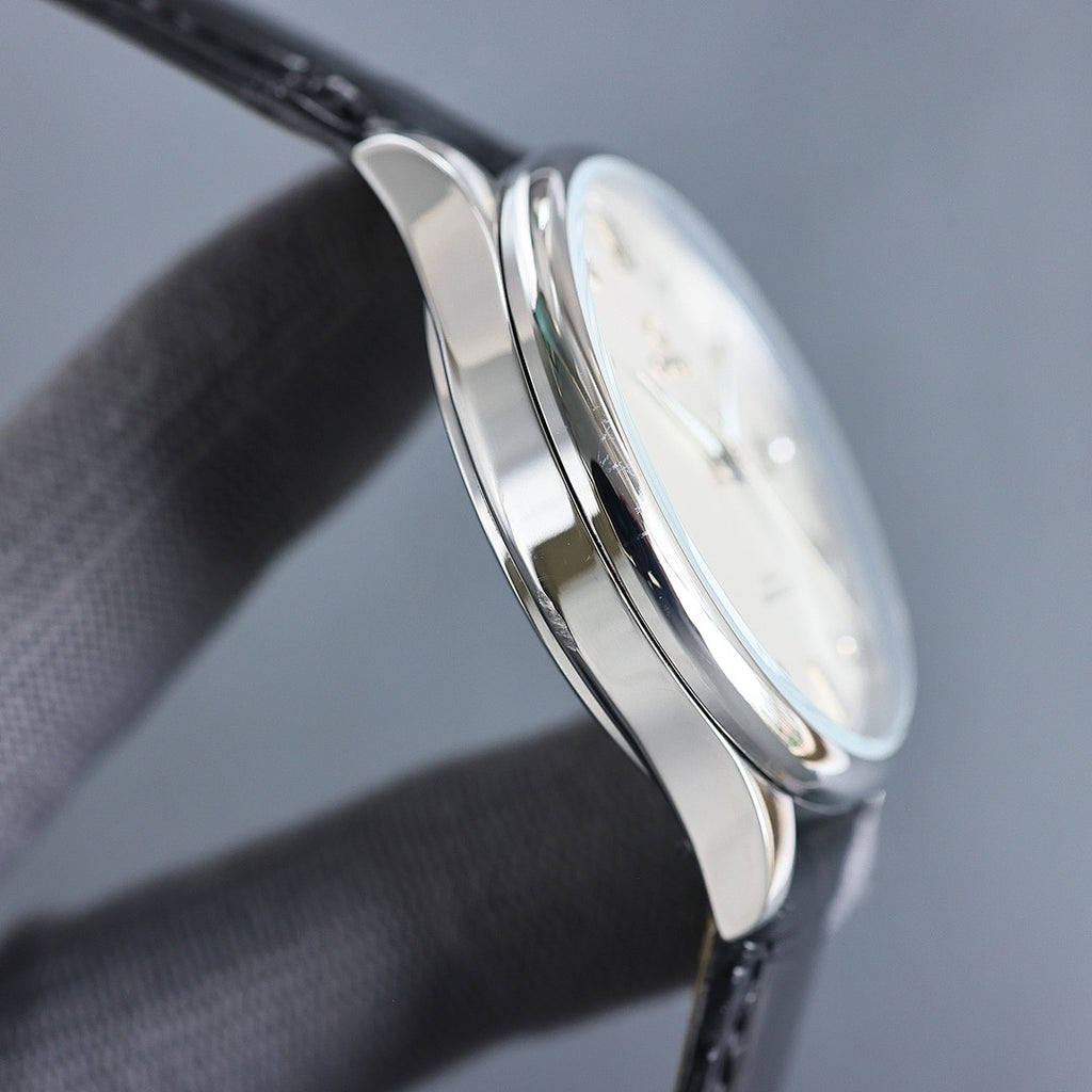 Wristwatch side profile with polished silver case and black leather strap
