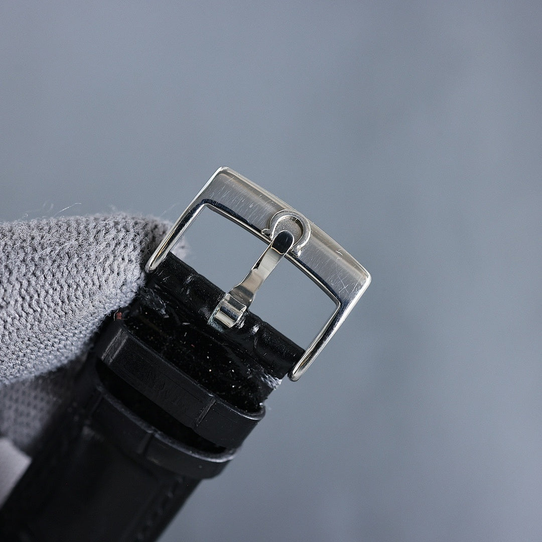 Wristwatch with black leather strap and silver clasp, side view of caseback