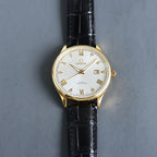 Gold Omega wristwatch with white dial, Roman numerals, black leather strap