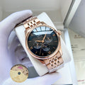 Omega watch with rose-gold metal bracelet and dark blue dial on white display pillow.