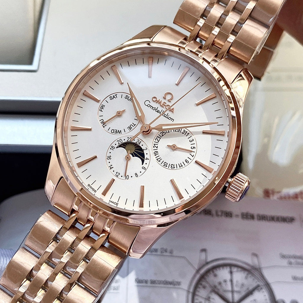 Rose-gold tone wristwatch with white dial, subdials, and metal link bracelet in a box.