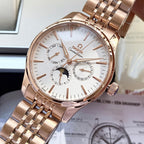 Rose-gold tone wristwatch with white dial, subdials, and metal link bracelet in a box.