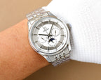 Omega watch on wrist with silver steel bracelet and white dial with moonphase subdial