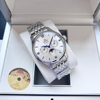 Omega wristwatch with white dial and silver metal bracelet on a white watch cushion