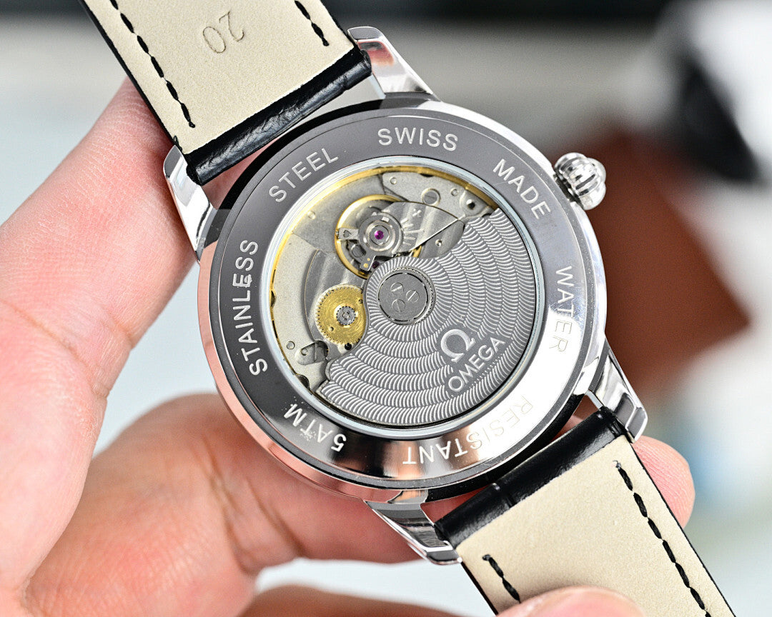 Stainless steel watch case back with visible automatic movement and black strap