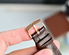 Leather watch strap with metal buckle clasp in rose-tone finish