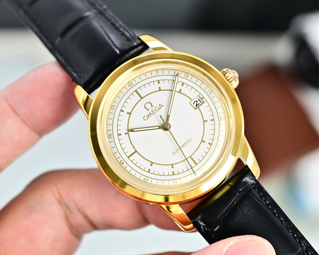 Gold Omega automatic wristwatch with black leather strap and white dial