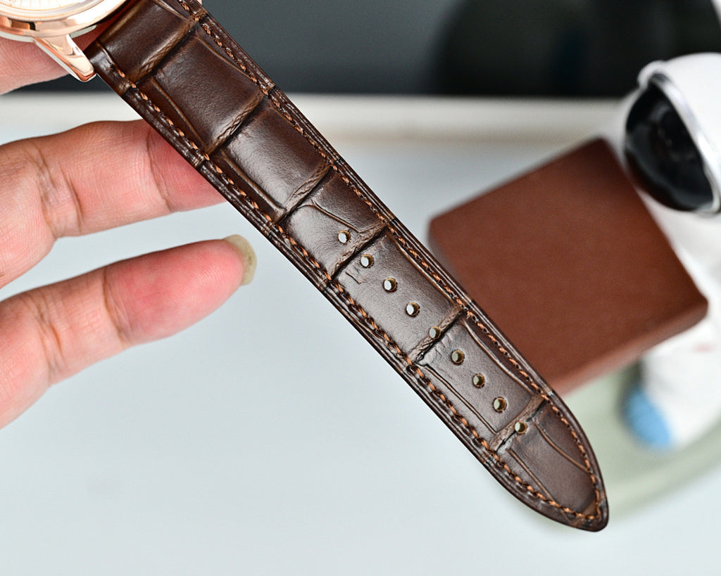 Brown leather watch strap with stitched holes and textured underside