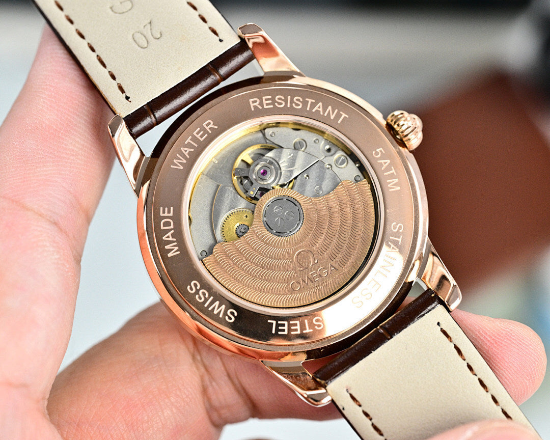 Omega automatic watch caseback in rose-tone metal with water resistant text