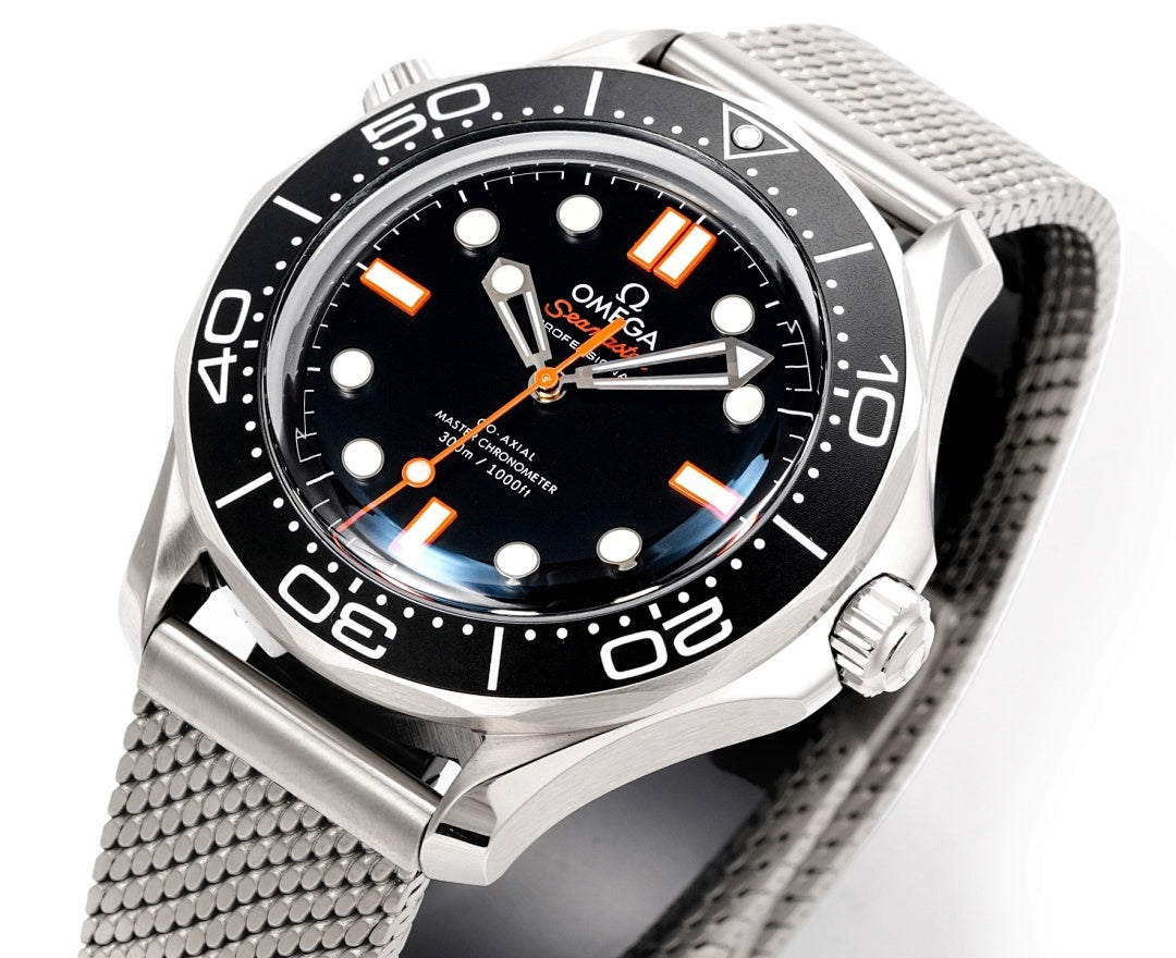 Wristwatch front with black dial, orange hour markers, bezel and mesh band
