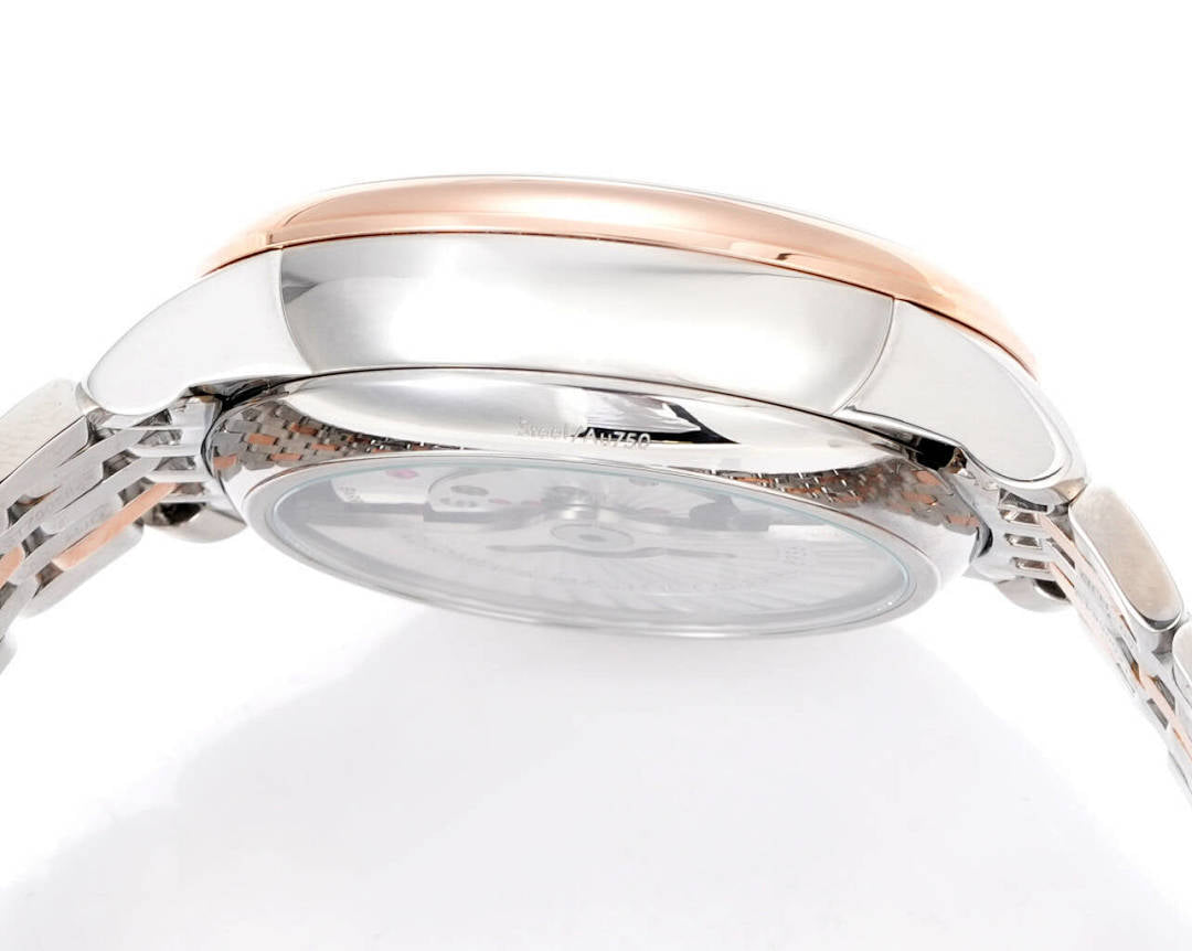 Stainless steel watch caseback with rose-gold rim and crown