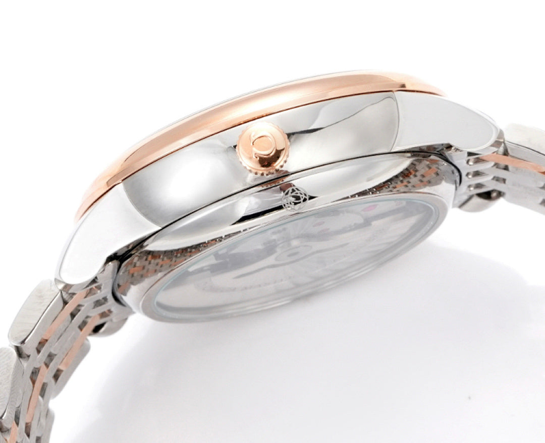 Watch caseback detail with rose-gold crown head and polished silver metal