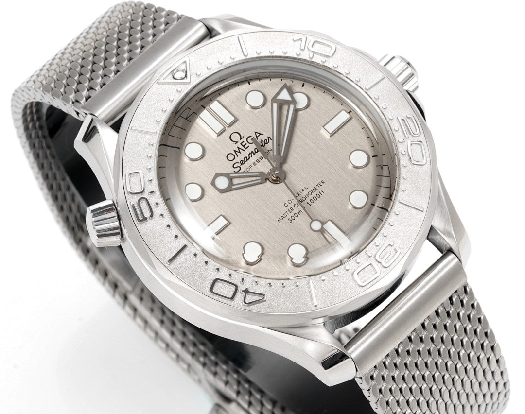 Stainless steel diver watch with gray mesh bracelet and baton hour markers, angled view.