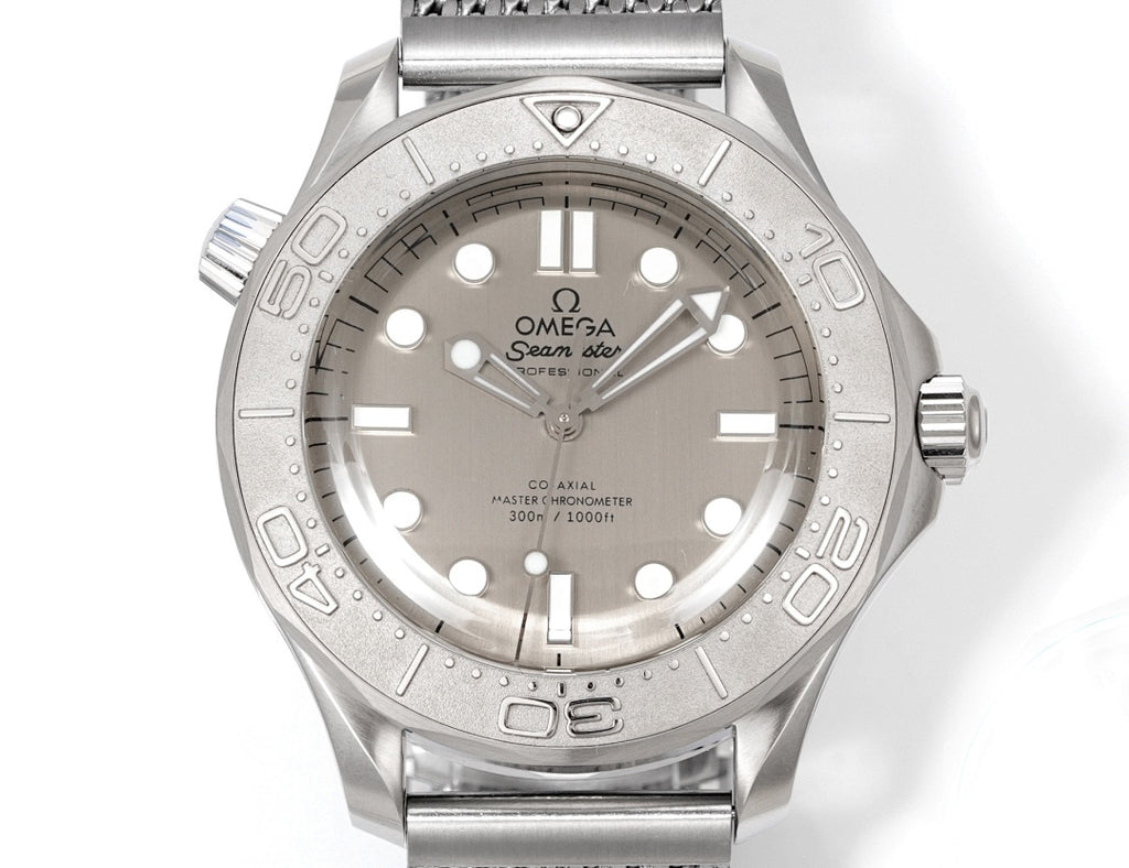 Stainless steel diver watch with silver dial, baton markers, and gray metal mesh bracelet.