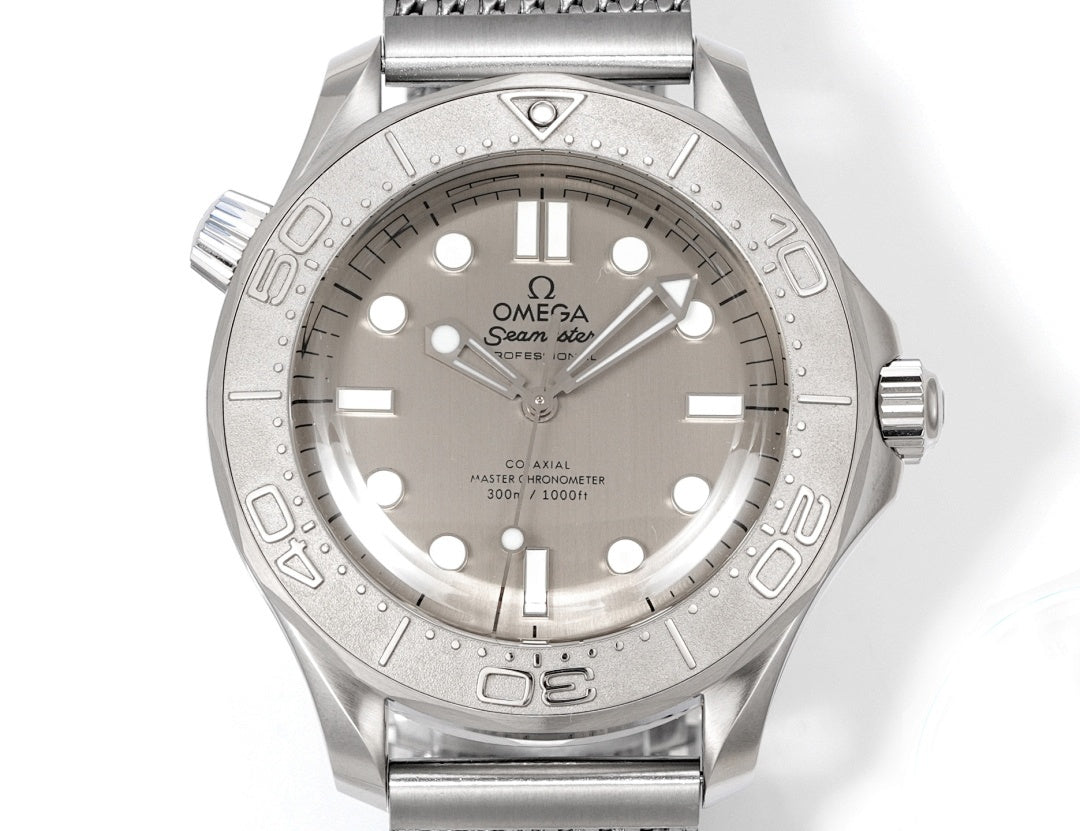 Stainless steel diver watch with silver dial, baton markers, and gray metal mesh bracelet.