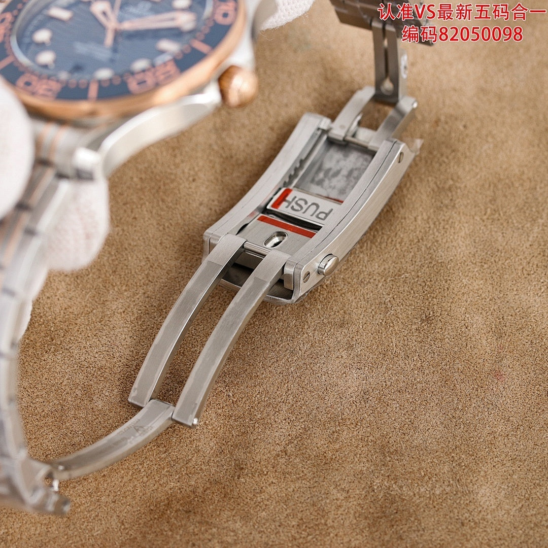Omega watch bracelet clasp detail with raised brand lettering on metal strap