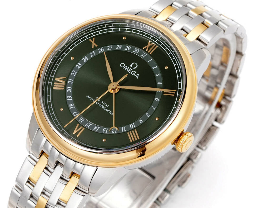 Omega watch angled close-up with green dial, gold bezel, two-tone metal bracelet