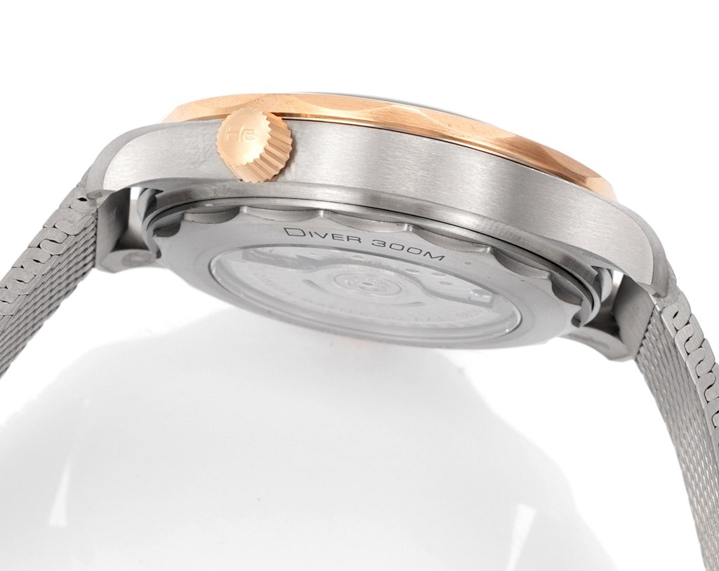Omega watch caseback underside, brushed metal case, crown and mesh strap visible