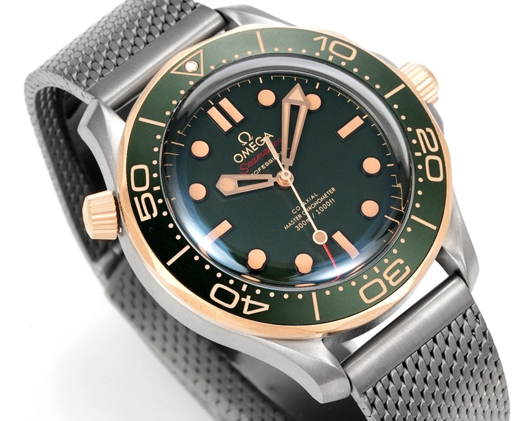 Omega watch angled view with green dial, gold-tone indices and hands, metal mesh strap