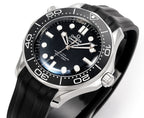 Omega watch face close-up with black dial, silver bezel, and black rubber strap.