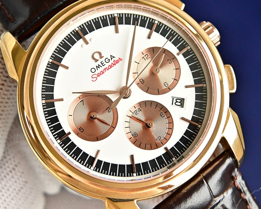 Omega Seamaster watch close-up: gold bezel, white dial, brown subdials, leather strap.