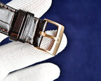 Omega watch brown leather strap with gold buckle and keeper.
