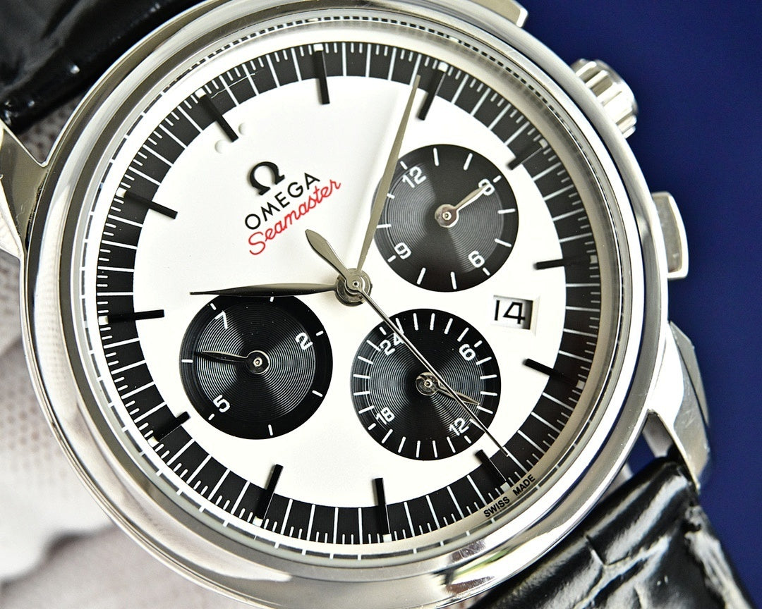 Omega Seamaster chronograph dial with black subdials, white center, and gold hands