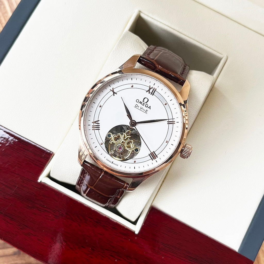Omega De Ville wristwatch in box with white dial, rose-gold case, brown leather strap.