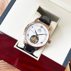 Omega De Ville wristwatch with rose-gold case, black leather strap, white dial.