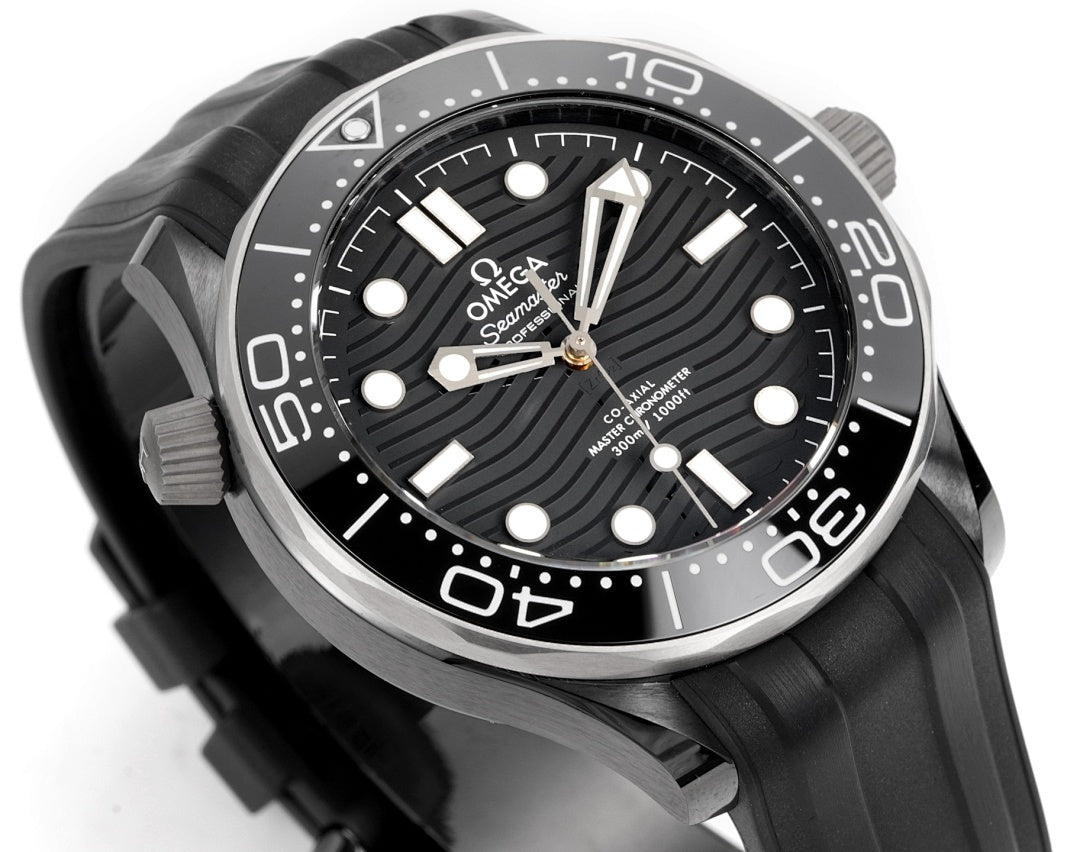 Black dial diver watch with silver bezel, white markers, and black rubber strap.