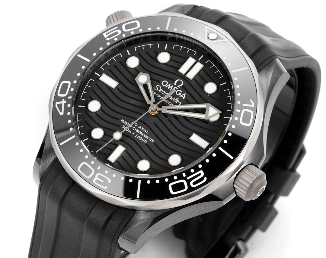 Diver watch with black rubber strap, black dial, and silver hands and markers.