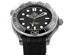 Black dial diver watch with silver bezel and black rubber strap, three-hand layout.