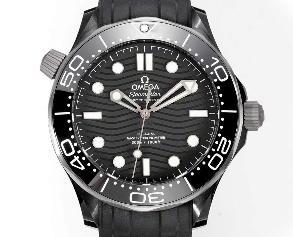 Black dial diver watch with stainless bezel and black rubber strap.