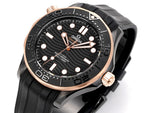 Black rubber diver watch front with rose-gold bezel, dark dial, and five gold-tone markers.