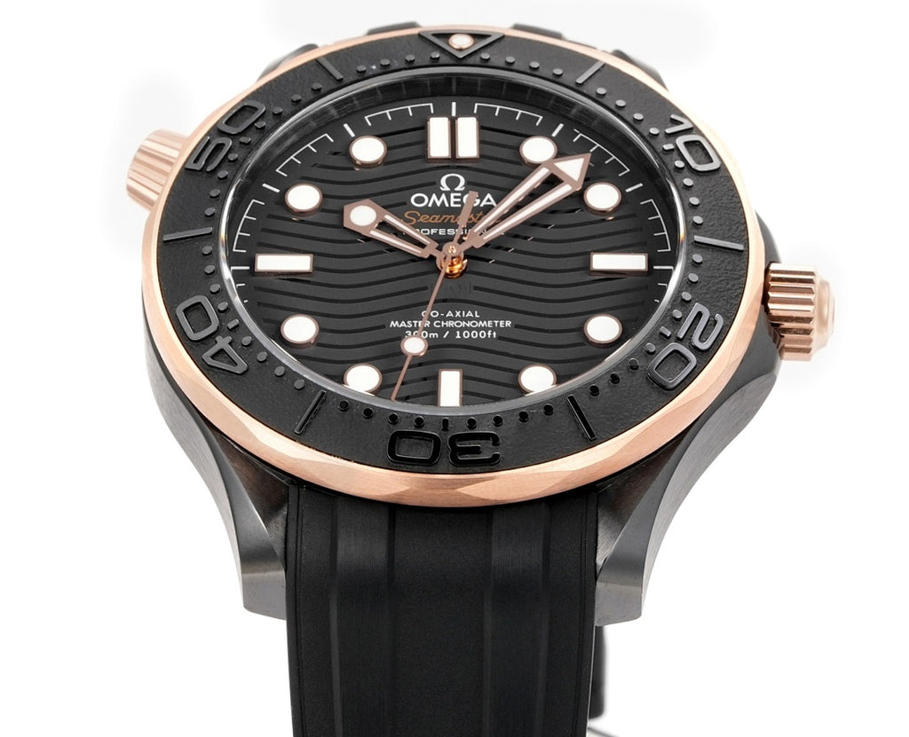 Front view of black rubber diver watch with rose-gold bezel and circular black dial.